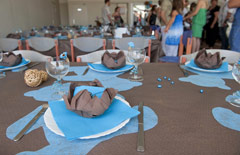 Stół na przyjęciu z okazji chrztu z dekoracjami w kolorze błękitnym.
